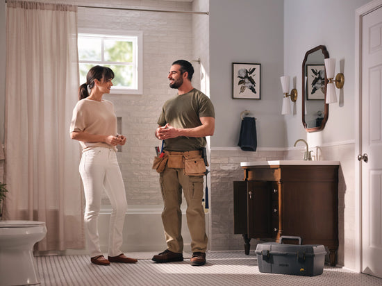 Plumber talking to homeowner in her home's bathroom