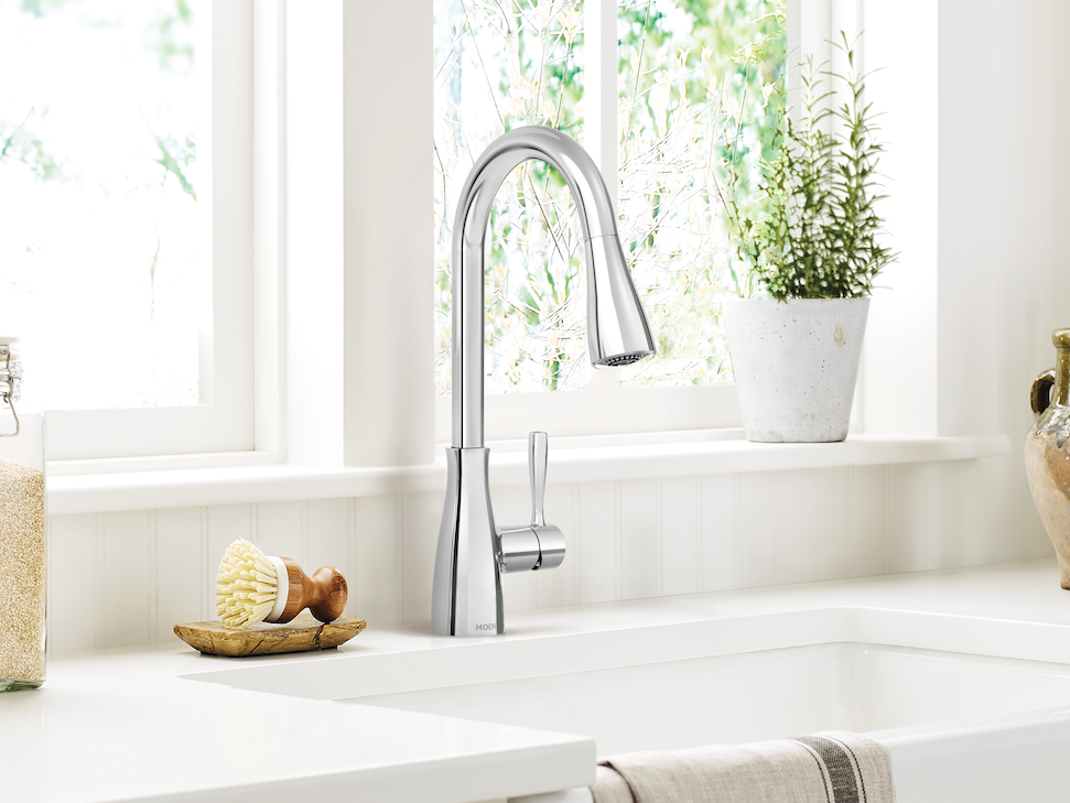 White kitchen sink with faucet in a bright room with natural light