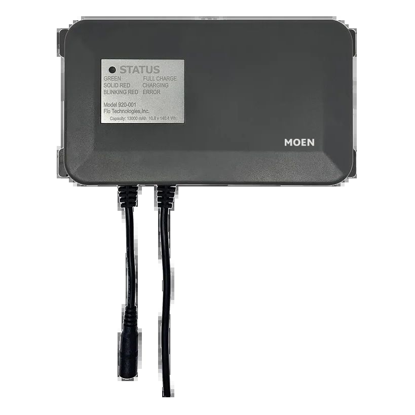 A dark gray Moen status box with a white label showing charging and running status, with two black cables hanging from the bottom, on a white background.