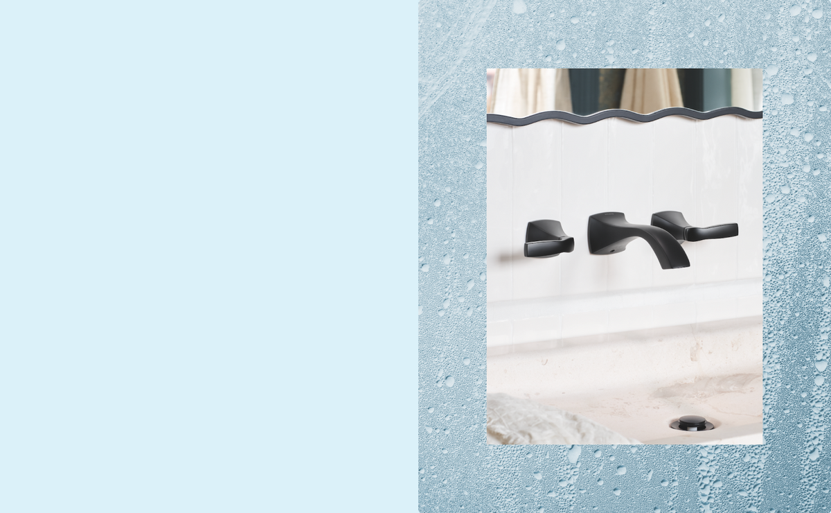 A matte black bathroom faucet set with two separate handles and a curved spout, mounted on a white wall above a sink. The photo is framed by a textured icy blue border with water droplets on the left and right sides.