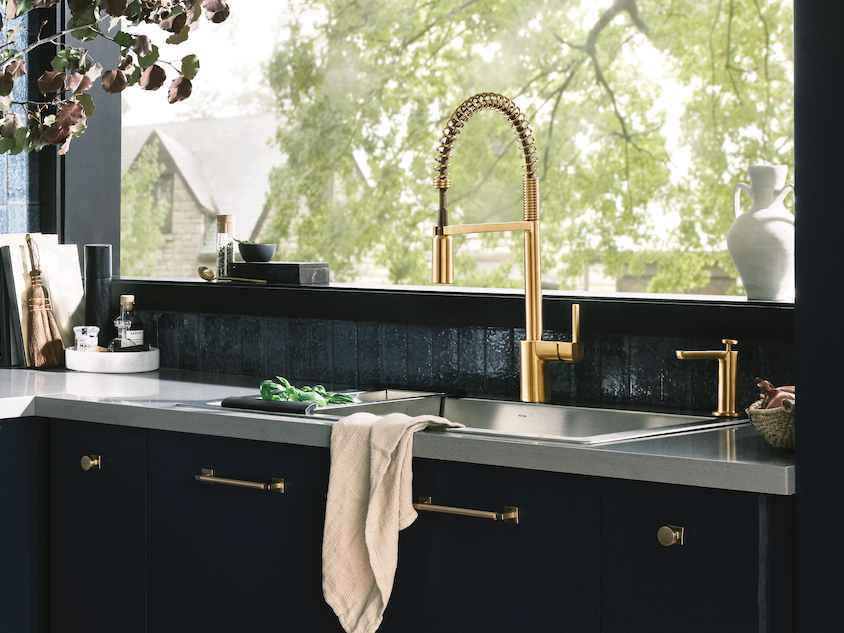 Align Kitchen Sink Faucet in a Modern kitchen with blue tiled walls and cabinets, featuring a window view.